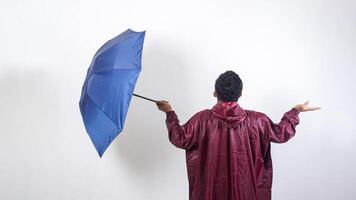 Rear view of man in red raincoat holds umbrella checking if rain stopped isolated on white background photo