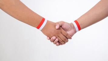 Two men with red and white wristband doing handshakes isolated on white background photo