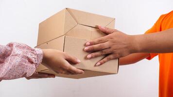 Close up of customer taking a package box given by delivery man in orange t-shirt isolated on white background photo