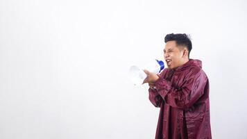 Asian man in red raincoat shout using megaphone isolated on white background photo