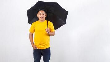 Handsome Asian man holding an umbrella isolated on white background photo