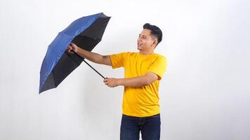 Smiling Asian man holds blue umbrella isolated on white background photo