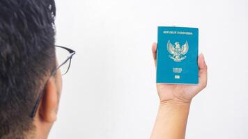 Yogyakarta, Indonesia, 2025 - Man hand shows Indonesian passport document isolated on white background photo