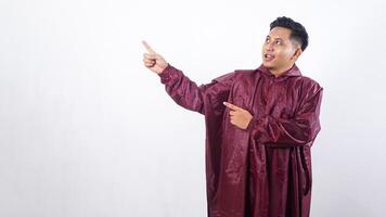 Portrait of Asian man in red raincoat pointing at empty space for advertisement or copy space concept isolated on white background photo