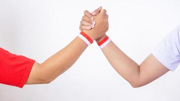 Two men with red and white wristband doing unity handshake isolated on white background photo