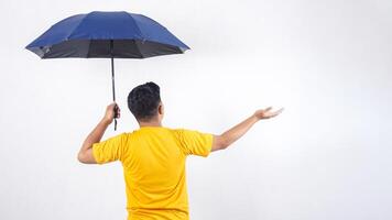 Rear view of man holding umbrella checking if rain stopped isolated on white background photo
