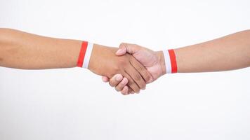 Two men hands with red and white wristband doing handshakes isolated on white background photo