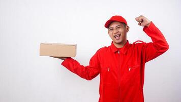 Asian Delivery man in red uniform with package box parcel showing happy face expression isolated on white background photo