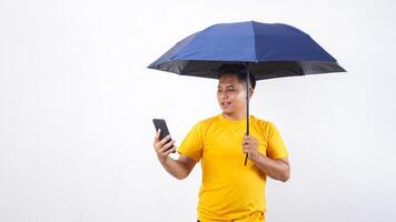 Asian man holding an umbrella and smartphone isolated on white background photo