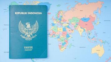 Yogyakarta, Indonesia, 2025 - Indonesian passport isolated on world map background photo