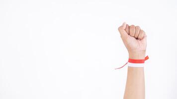 Hand clenched in the air as symbol of freedom and tie the wrist with red and white ribbon isolated on white background photo