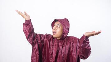 Portrait of Asian man in red raincoat checking if rain stopped isolated on white background photo