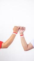 Two men hands with red and white wristband doing pinky promise sign isolated on white background photo