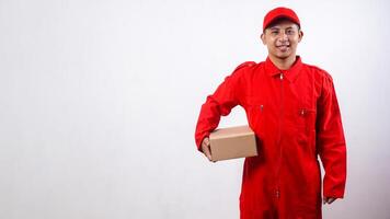Delivery man in red uniform with cardboard parcel box isolated on white background photo
