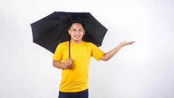 Asian man holds an umbrella and presenting empty space for copy space concept isolated on white background photo