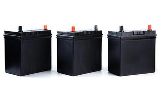 Row of three matching automotive batteries isolated on white background. Standard car power units for catalog listing, garage, or online store. photo