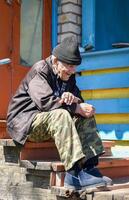 Smiling elderly Russian man with a cigarette, gazing into the distance with hope and peace, a rare moment of warmth in a hard rural life photo