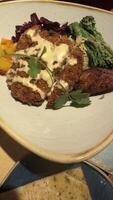 Plated Meal with Fried Cutlet, Vegetables, Rice, and Sauce photo