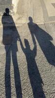 Shadows of Three Figures on Asphalt Surface photo