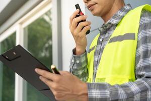 inspector or engineer is inspecting construction and quality assurance new house using a checklist. Engineers or architects or contactor work to build the house. photo