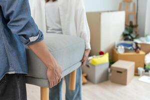 Moving house, relocation. Couple help set sofa and move furniture for new apartment, inside the room was a cardboard box contain personal belongings. move in the new apartment or condominium photo