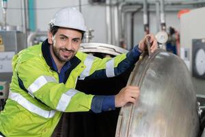 portrait Engineer or factory managers wearing safety helmet inspect the machines in the production line. The inspector opened the machine to test the system to meet the standard. machine maintenance photo