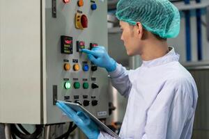 quality supervisor or food or beverages technician change parameter and condition control food or beverages before send product to the customer. Production leader recheck machine photo