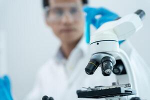 Scientist analyze biochemical samples in advanced scientific laboratory. professional use microscope look microbiological developmental of viral. Biotechnology research in science lab. photo