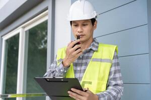 inspector engineer is inspecting construction and quality assurance new house using a checklist. Engineers or architects or contactor work to build the house before handing it over to the homeowner photo