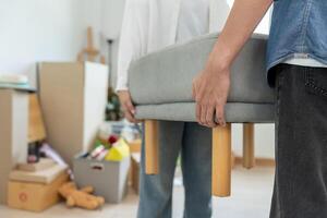 Moving house, relocation. Couples help set and move furniture for new apartment, inside the room was a cardboard box contain personal belongings. move in the new apartment or condominium photo