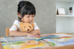 children relax read story book for bear doll. daughter and reading a story. learn development, childcare, education, storytelling, practice, imagine, reduce addiction mobile phone photo