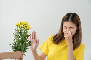 young woman sneezing in a handkerchief or blowing in a wipe, allergic to wild spring flowers or blossoms during spring. allergic reaction, respiratory system problems photo
