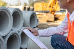 inspector or engineer is inspecting construction house using a checklist. Engineers and architects or contactor count materials for construction. Building, check, insurance house, quality. photo