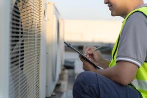 maintenance engineer work on the roof of factory. contractor inspect compressor system and plans installation of air condition systems in construction. Checklist, inspector, control photo