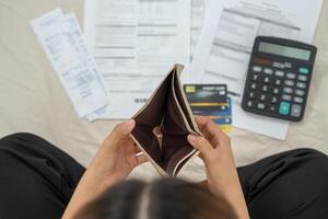 Stress and headache woman with large bills or invoices no money to pay to expenses and credit card debt. shortage, Financial problem, bankruptcy, mortgage, loan, bankrupt, poor, empty wallet photo
