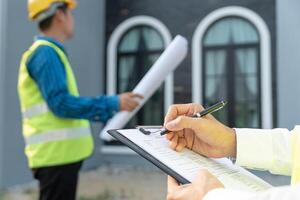 engineer is inspecting construction and quality assurance new house using a checklist. Engineers or architects or contactor work to build the house before handing it over to the homeowner photo
