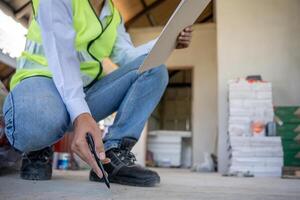 inspector is inspecting construction and quality assurance new house using a checklist. Engineers or architects or contactor work to build the house before handing it over to the homeowner. photo