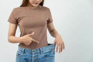 Woman showing results of diet. Beautiful shape. female have a reduced waist size after under going a weight loss corse. can not wear jeans due to weight loss. balance, control, routines, exercise. photo