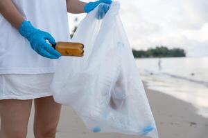 Volunteer pick up trash garbage at the beach and plastic bottles are difficult decompose prevent harm aquatic life. Earth, Environment, Greening planet photo
