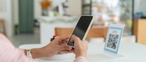 Women use smartphone to scan QR code for order menu in cafe restaurant with a digital delivery. Choose menu and order accumulate discount. E wallet, technology, pay online, credit card, bank app. photo