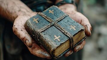 Dirty Hands Holding Ancient Book with Crosses photo