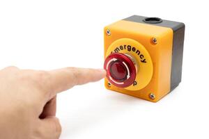 Hand pressing Emergency stop button. Big Red emergency button or stop button for manual pressing. Isolated on white background. photo
