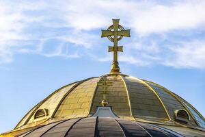 A cross on top of a building with a blue sky in the background photo