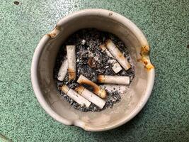 Cigarette ashtray full of cigarette ash photo