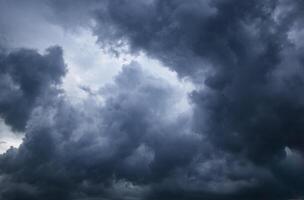 dark sky with heavy clouds converging and a violent storm before the rain.Bad or moody weather sky and environment. carbon dioxide emissions, greenhouse effect, global warming, climate change photo