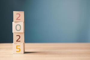 2025 on wooden cube stack blocks on the table. start a happy new year 2025. strategy target, goal, plan concept.copy space. photo