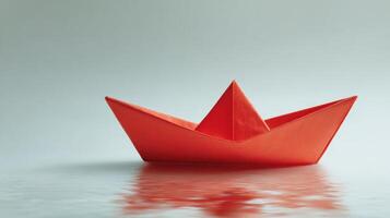 A red paper boat floating on the water photo