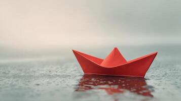 A red paper boat floating in the water photo