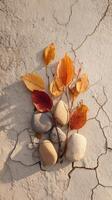 A rock with leaves and pebbles on a cracked wall photo