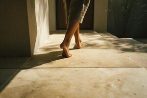 A woman walking on a stone floor with her bare feet photo